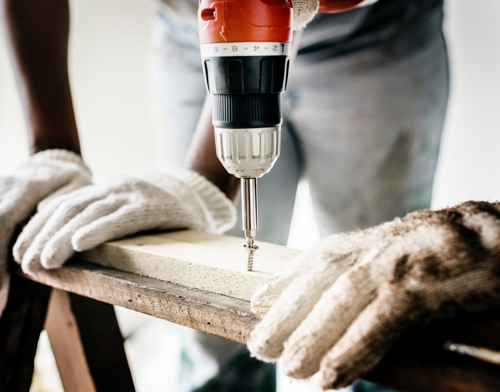 using a drill to fix an item on the home